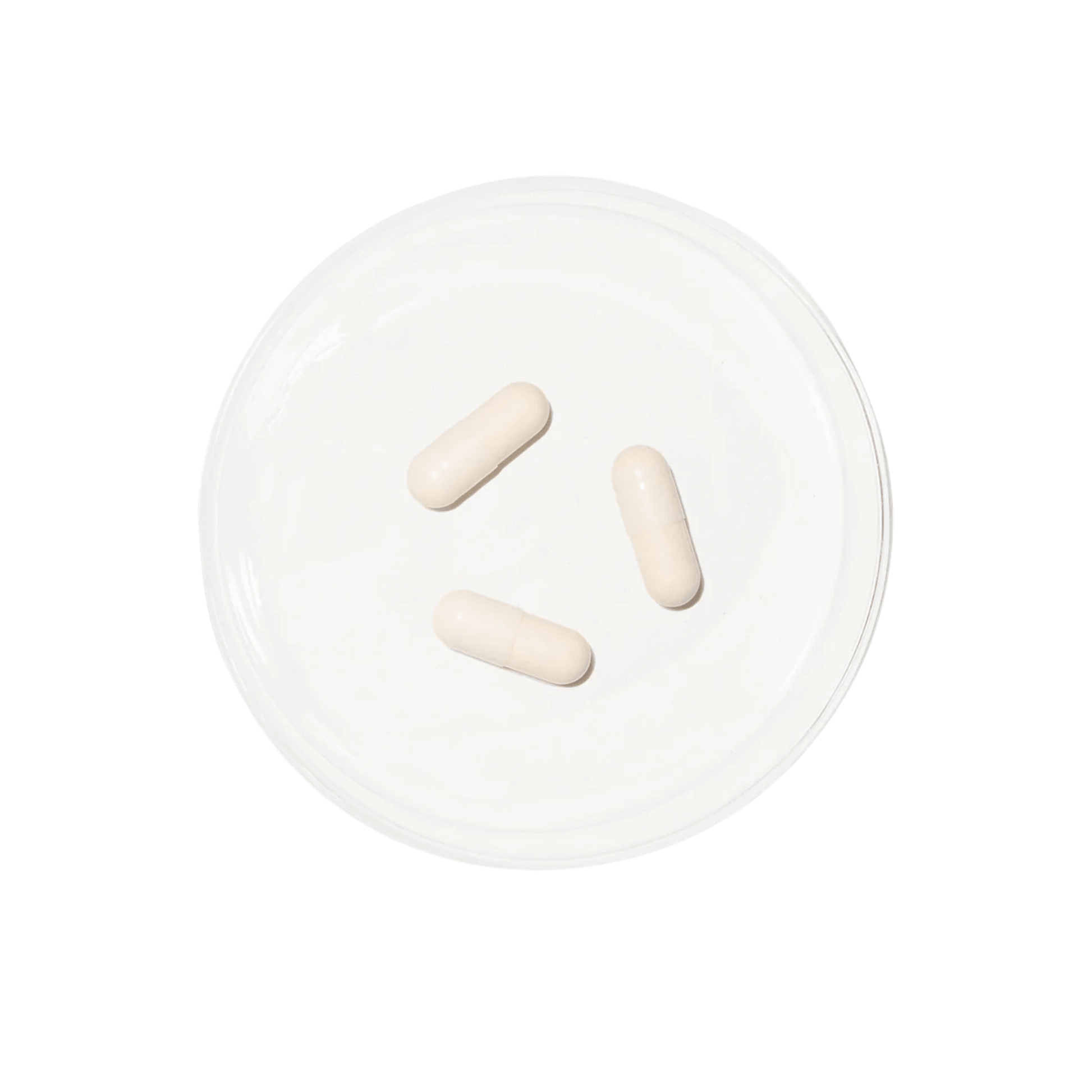 Three white Luminous Advanced repair capsules in a petri dish on a white background
