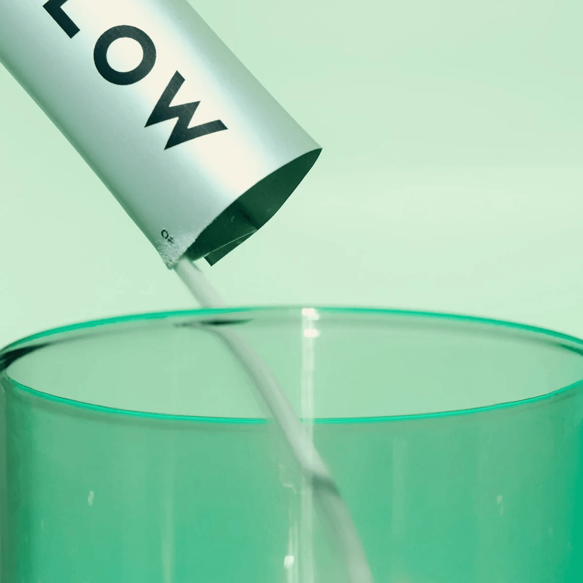 Vida Glow Original sachets being poured into a green glass