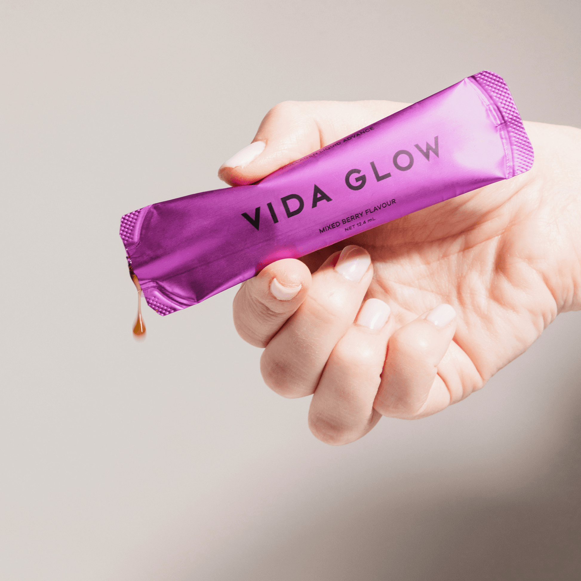 Vida Glow liquid advance sachet held in hand